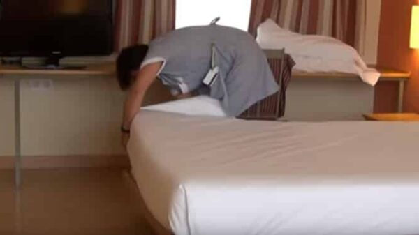 Una camarera de piso limpiando la habitación de un hotel