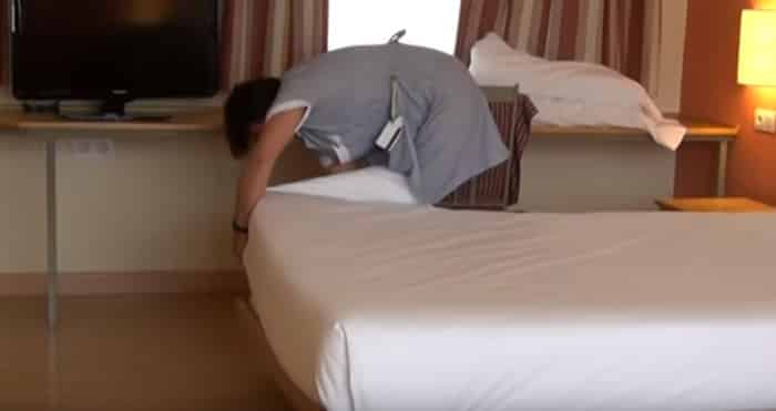Una camarera de piso limpiando la habitación de un hotel