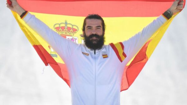 Regino Hernández celebra su medalla olímpica en el podio con la bandera de España