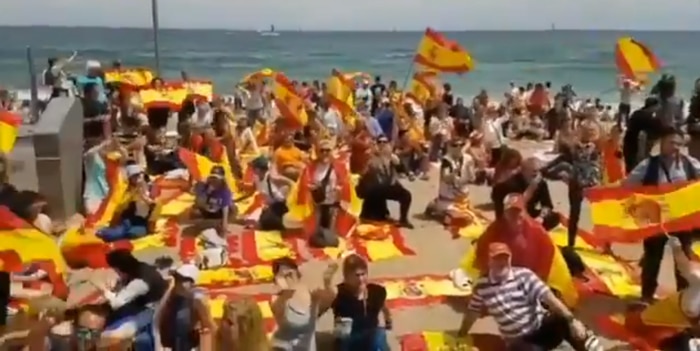 Banderas y toallas españolas en una playa catalana