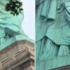 La mujer subida en las faldas de la Estatua de la Libertad