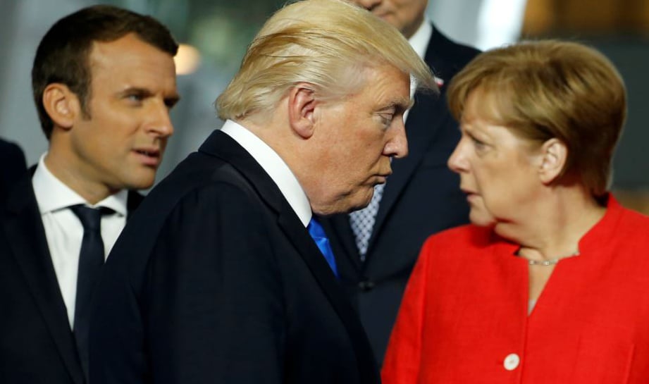 Donald Trump pasa por delante de Enmanuel Macron y Angela Merjel en una cumbre de la OTAN