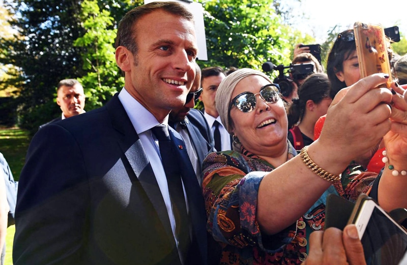 El presidente francés, Emmanuel Macron, posa con ciudadanos en los jardines del Elíseo
