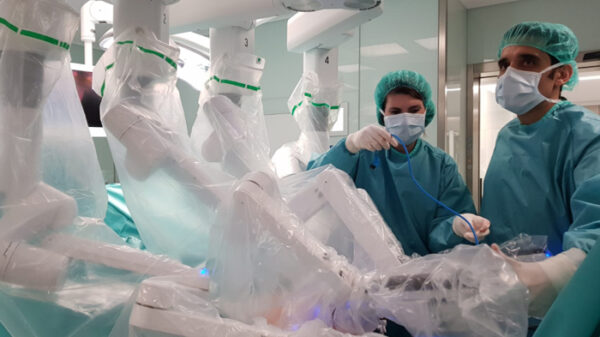 El doctor Cabello (derecha), colocando los brazos del robot quirúrgico antes de una intervención